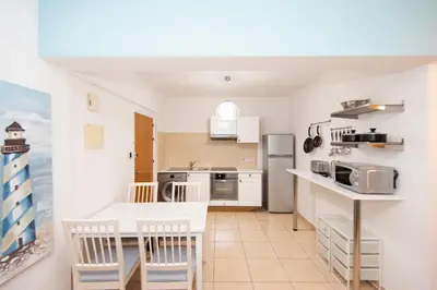 a kitchen with a table and chairs in a room at Olympia flat 201 in Larnaka