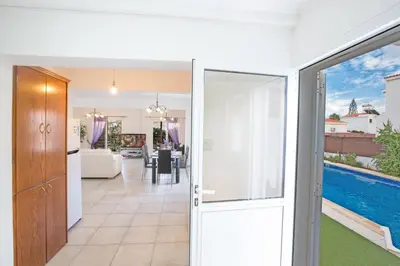 a sliding glass door leading into a living room with a pool at Villa Dionysos in Protaras