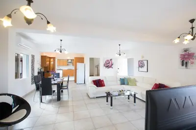 a living room with a white couch and a table at Villa Dionysos in Protaras