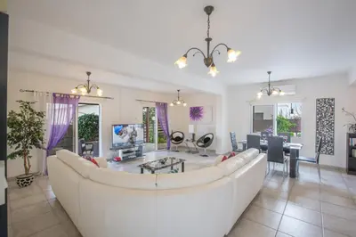 a living room with a white couch and a table at Villa Dionysos in Protaras
