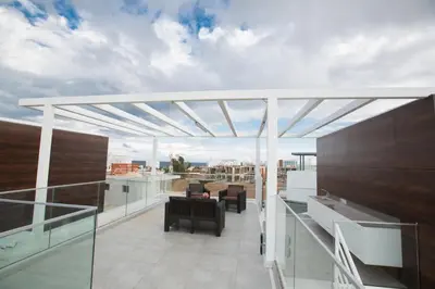 a roof deck with a pergola on a building at Oli Vine Villas in Protaras