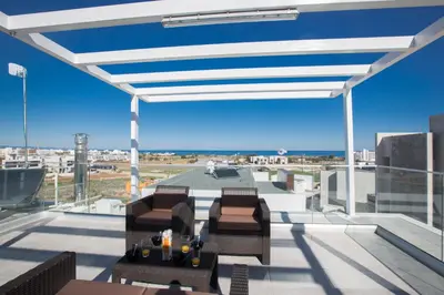a patio with chairs and a table on a roof at Oli Vine Villas in Protaras