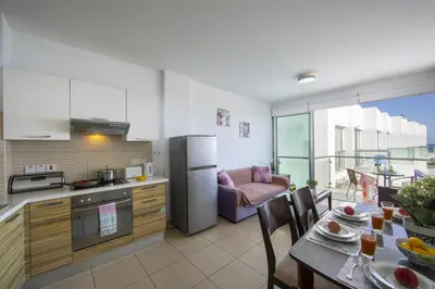 a kitchen and dining room with a table and a kitchen and a living room at Coralli A 305 in Protaras