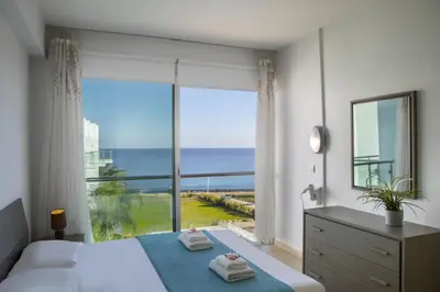 a bedroom with a bed and a large window with the ocean at Coralli A 305 in Protaras