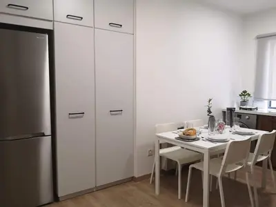a kitchen with a table with chairs and a refrigerator at Nemesis in Larnaka