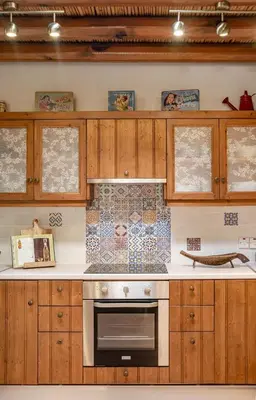 a kitchen with wooden cabinets and a stove at The Carob Tree Villa - Rustic Luxury Home With Access To Pool And Restaurant in Larnaka