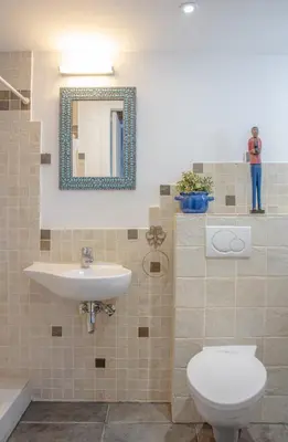 a bathroom with a sink and a toilet and a mirror at The Carob Tree Villa - Rustic Luxury Home With Access To Pool And Restaurant in Larnaka