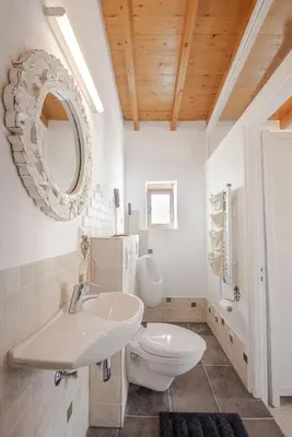 a bathroom with a sink and a toilet and a mirror at The Carob Tree Villa - Rustic Luxury Home With Access To Pool And Restaurant in Larnaka