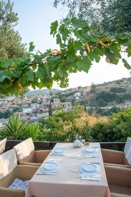 a table with plates on it with a view of a city at The Carob Tree Villa - Rustic Luxury Home With Access To Pool And Restaurant in Larnaka