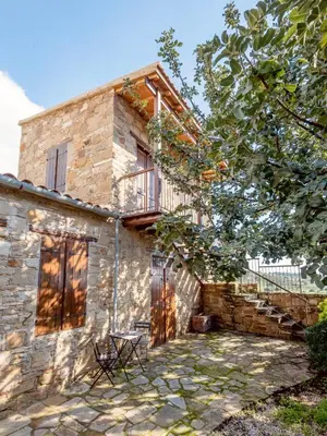 a stone house with a table in front of it at The Carob Tree Villa - Rustic Luxury Home With Access To Pool And Restaurant in Larnaka