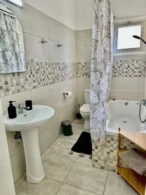 a bathroom with a sink and a tub and a toilet at Tsimintia Apt 25 in Larnaka
