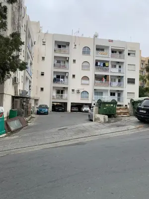 a large white building with cars parked in front of it at White Arches Modern Beautiful studio in Limassol