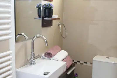a bathroom with a sink and a toilet and a mirror at Natali villa in a perfect location in Paralimni