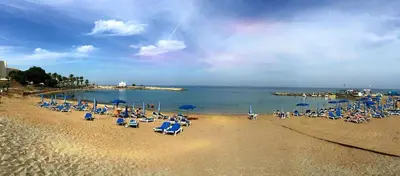 a beach with a bunch of chairs and umbrellas at Natali villa in a perfect location in Paralimni