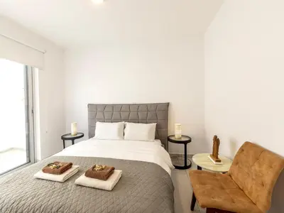 a bedroom with a large bed and a chair at Villa Zoe in Protaras