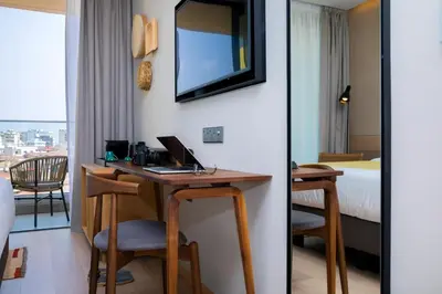 a hotel room with a desk with a computer on it at Hotel Indigo Larnaca by IHG-ADULTS ONLY in Larnaka