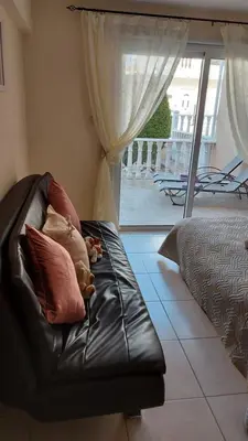 a leather couch with pillows on it in a living room at Nissi Golden Sands Holiday Apartment Free WiFi in Ayia Napa