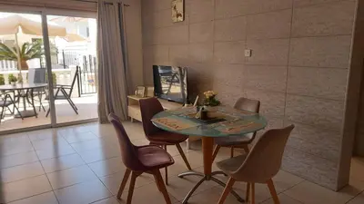 a dining room with a glass table and chairs at Nissi Golden Sands Holiday Apartment Free WiFi in Ayia Napa
