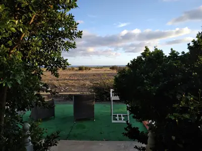 a yard with green grass and two lawn chairs at MERSINERA Paradise Garden 2 in Larnaka