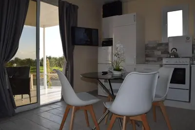 a kitchen with a dining table and white chairs at MERSINERA Paradise Garden 2 in Larnaka