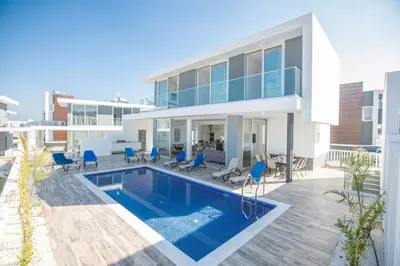 a house with a swimming pool and blue chairs at Protaras Olivine Villa OL17 in Protaras