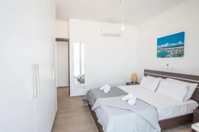 a bedroom with a bed with white sheets at Protaras Olivine Villa OL17 in Protaras