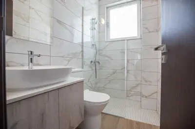 a bathroom with a sink and a toilet and a window at Protaras Olivine Villa OL17 in Protaras