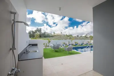 a kitchen with a view of a pool from a house at Olivine 3 Bedroom Villas in Protaras
