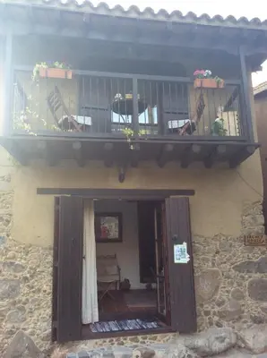 a building with a balcony with chairs and a table at Irene's House in Kakopetria