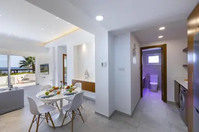 a kitchen and dining room with a table and chairs at Mackenzie Castella Beachfront Suite in Larnaka