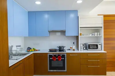 a kitchen with blue cabinets and a stove top oven at Mackenzie Castella Beachfront Suite in Larnaka