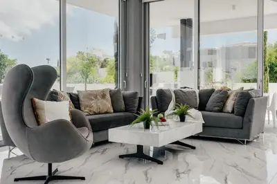 a living room with a couch and a table at Protaras Olivia Pearl Villa in Paralimni