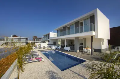 a house with a swimming pool in front of it at Protaras Olivine Pearl in Protaras