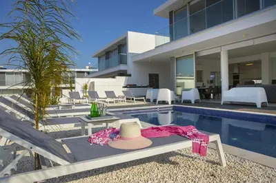 a hat sitting on a bench next to a swimming pool at Protaras Olivine Pearl in Protaras