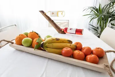 a tray of fruit on a table with a bottle at Protaras Villa Nicol 21 in Paralimni