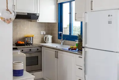 a kitchen with white cabinets and a white refrigerator at Protaras Villa Nicol 21 in Paralimni