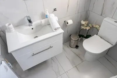 a white bathroom with a toilet and a sink at Protaras Villa Nicol 21 in Paralimni