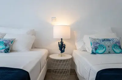 two beds in a room with a lamp on a table at Protaras Villa Nicol 21 in Paralimni
