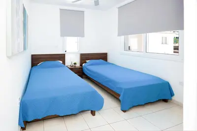 two beds in a room with blue sheets at Villa Blue Sky in Protaras