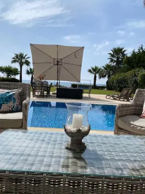 a candle sitting on a table next to a pool at Ionion Beachfront Villa in Ayia Napa