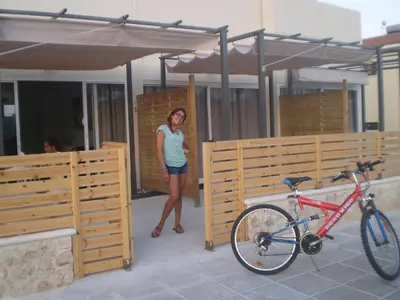 a woman is standing next to a bike at Sunny Holiday Apartments in Protaras
