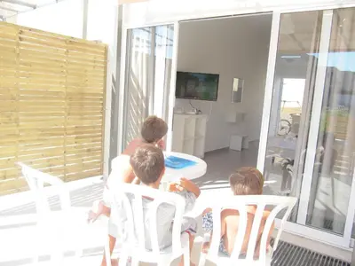 a group of children sitting around a table in a room at Sunny Holiday Apartments in Protaras