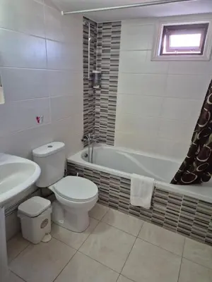 a bathroom with a toilet and a tub and a sink at Myriama Apartments in Ayia Napa