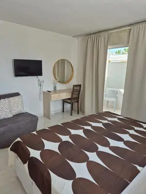 a bedroom with a bed and a desk with a mirror at Myriama Apartments in Ayia Napa