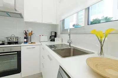 a white kitchen with a sink and a counter at Villa Caren in Paralimni
