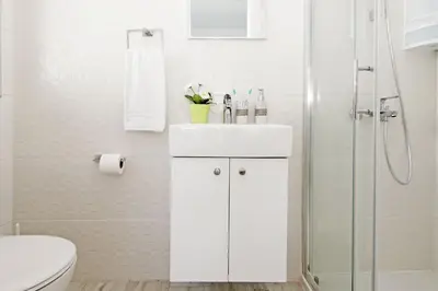 a white bathroom with a sink and a shower at Villa Caren in Paralimni