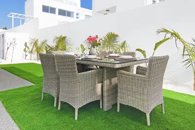 a rattan table and chairs on a lawn at Villa Paradisia in Ayia Napa