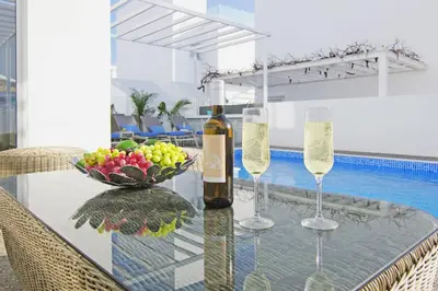 a glass table with two wine glasses and a bowl of fruit at Villa Paradisia in Ayia Napa