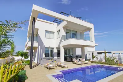 a white villa with a swimming pool in front of it at Villa Amelia in Paralimni