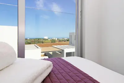 a bedroom with a bed and a large window at Villa Amelia in Paralimni